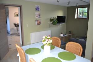 ein Zimmer mit einem Tisch mit einer Blumenvase darauf in der Unterkunft Gîte de l'Espinette in Godarville