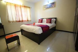 a bedroom with a large bed with red pillows at villas holiday family home service in Surat