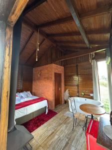 a bedroom with a bed and a table in a room at Chalé na Serra Urubici in Urubici