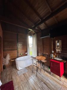 a bathroom with a tub and a table and a sink at Chalé na Serra Urubici in Urubici