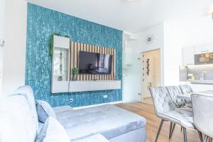 Una sala de estar con un sofá y un televisor en una pared. en Sweet 2BR & 1LR Apartment, Around Donaustadt, en Viena
