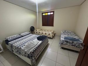 a bedroom with two beds and a window at Casa em Lençóis in Lençóis