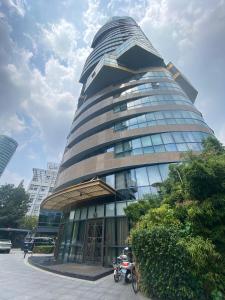 un edificio alto con una moto parcheggiata di fronte di Shanghai downtown Tyms B&B Near Hongqiao Metro and Jiaotong University High view 3bedroom&2bathroom a Shanghai