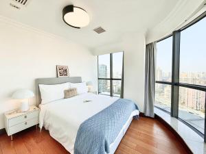 una camera bianca con un grande letto e ampie finestre di Shanghai downtown Tyms B&B Near Hongqiao Metro and Jiaotong University High view 3bedroom&2bathroom a Shanghai