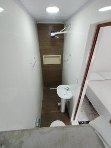 a small bathroom with a toilet and a sink at Suítes em Cananéia SP in Cananéia