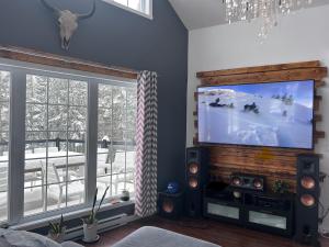 a living room with a large flat screen tv at Night Sky Cottage in Saint-Joachim