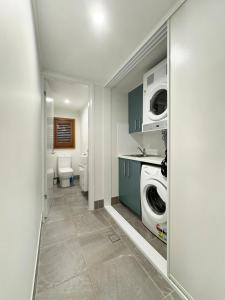 ein Badezimmer mit einer Waschmaschine, einer Waschmaschine und einem Trockner in der Unterkunft Wongalinga Beachfront Apt 3 in Mission Beach
