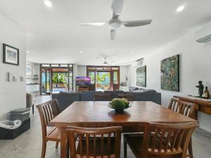 ein Esszimmer und ein Wohnzimmer mit Tisch und Stühlen in der Unterkunft Wongalinga Beachfront Apt 3 in Mission Beach