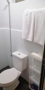 a bathroom with a white toilet and towels at Rosie's Staycation in Trece Martires, Cavite in Quintana