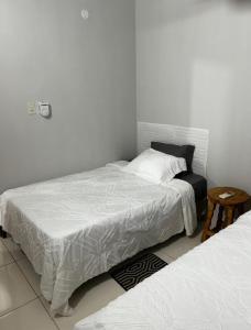 a bedroom with two beds with white sheets and a table at Comodo Dpto bien equipado cerca de Aeropuerto y COP Comité Olímpico Py in Luque