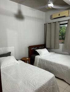a bedroom with two beds and a window at Comodo Dpto bien equipado cerca de Aeropuerto y COP Comité Olímpico Py in Luque