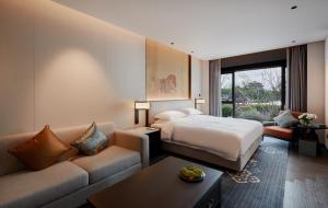 una camera d'albergo con un letto e un divano di 西安曲江芳林苑酒店 a Xi'an