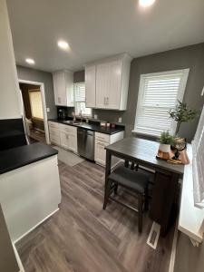 una cucina con mobili bianchi e un tavolo di legno di The retreat on 1st Street a Cherokee