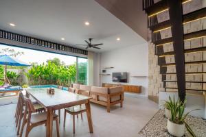 a dining room and living room with a table and chairs at Sanur Bali Villas by Premier Hospitality Asia in Sanur