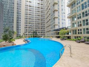 a large swimming pool in a building with tall buildings at Apartemen 69m 2 Kamar Tidur dan 2 Kamar Mandi Pemandangan Kota in Medan