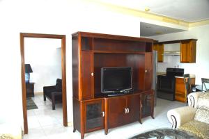 a living room with a flat screen tv in a entertainment center at Embassy Royale in Kingston