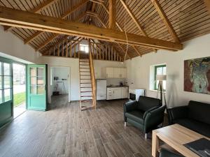 a living room with a wooden ceiling and a kitchen at Ferienhaus nahe Schweriner Seenplatte in Wendorf