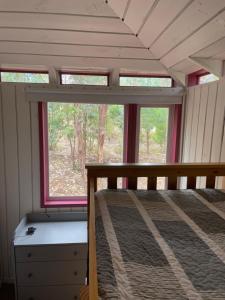 QuiñicabeにあるNaturaVista Cabins Matanza 13kmの小さな家の中にあるベッドルーム(ベッド1台、窓付)