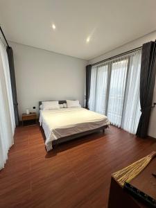 バトゥにあるVilla Danishのベッドルーム1室(白いシーツと窓付)