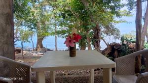a white table with a vase with flowers on it at Cabaña Colibrí Balgue in Altagracia +6 photos