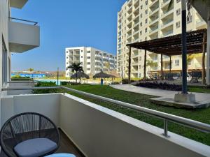 ein Balkon mit einem Stuhl und Blick auf ein Gebäude in der Unterkunft Family apartment with great amenities - bluu 103 in Mazatlán