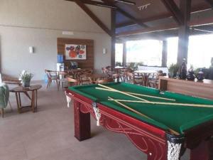 a pool table in a room with tables and chairs at Malawi Resort Experience INN in Porto De Galinhas