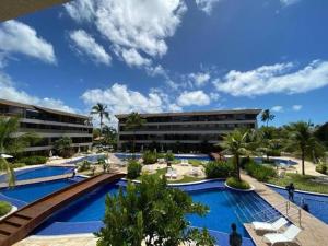 a resort with a pool with palm trees and a building at Malawi Resort Experience INN in Porto De Galinhas