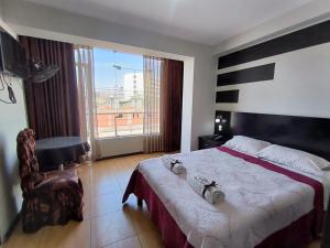 a bedroom with a large bed and a large window at La Lisera Suite Residencial in Tacna