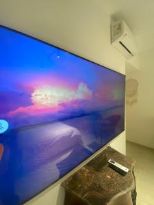 Un monitor de computadora grande en una pared con un control remoto en Vibes Master, en Madinaty