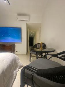 Un dormitorio con una cama, una mesa y un televisor. en Vibes Master, en Madinaty