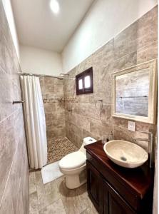 Un baño con inodoro, ducha y lavabo. en Hotel Carretas 2, en Jalpan