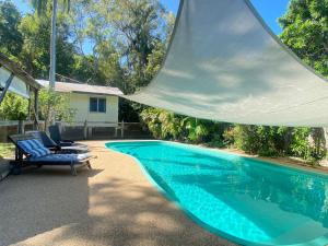 a swimming pool with two chairs next to a house at The Captains Manor On Cook 5 in Arcadia