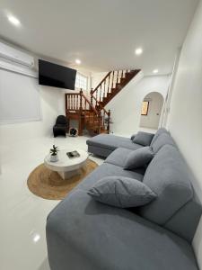 a living room with a blue couch and a table at Bophut Fisherman's Village Pink Sky Villa in Koh Samui 