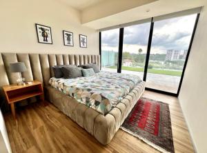 a bedroom with a large bed with a large window at Departamento Deluxe 2H-48 in Guadalajara