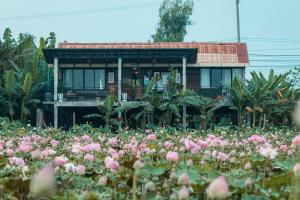 una casa con un campo di fiori davanti di Pomelo Outpost Cambodia ដំណាក់ភ្នំក្រោម a Phumĭ Rœssei Lŭk