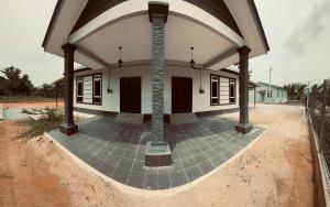 an outside view of a house with a brick patio at The 736 Homy in Melur