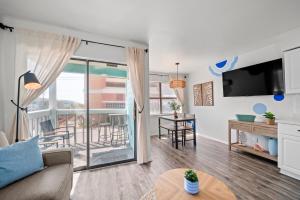 a living room with a couch and a balcony at Vitamin Sea in Gulf Shores