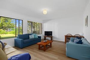 a living room with two blue couches and a table at Rockpools in Mollymook