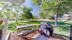 a picnic table with a backpack next to a bench at Cozy Four Bedroom Family Retreat with Yard and Air Hockey in Centennial