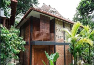 a house with a balcony on the side of it at KK by Secoms in Yogyakarta