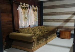a couch sitting in a room with a curtain at KK by Secoms in Yogyakarta