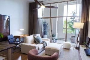 ein Wohnzimmer mit einem weißen Sofa und Stühlen in der Unterkunft Surry Hills Loft-Style Heritage 1BR - Indoor Pool, Sauna & Gym in Sydney