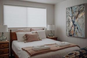 a bedroom with a large bed with two towels on it at Sea Breeze Freycinet - Hot Tub in Coles Bay