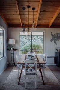 a dining room with a table and chairs and a window at Sea Breeze Freycinet - Hot Tub in Coles Bay