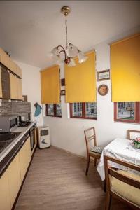uma cozinha com armários amarelos, uma mesa e uma sala de jantar em Apartment History em Zagreb
