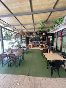 um restaurante com mesas e cadeiras e pessoas sentadas a mesas em KohTaoHostel em Ko Tao mais 24 fotografias