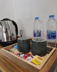 a tray with two coffee mugs and two bottles of water at TipThong Hut - Tropic Garden Resort in Rayong