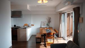 a kitchen and a living room with a table in a room at エンズプラザライカム in Okinawa City