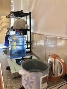 a kitchen counter with a measuring cup on a stove at Elatap Studio Overlooking Baguio in Baguio