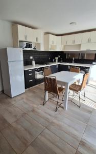 a kitchen with a white table and chairs at Hermosa Casa Con pileta y quincho in Villa Nueva